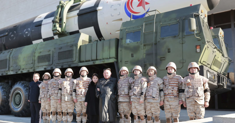 North Korean leader Kim Jong Un, center, and his daughter, center left, pose with soldiers in front of the Hwasong-17 intercontinental ballistic missile in North Korea.