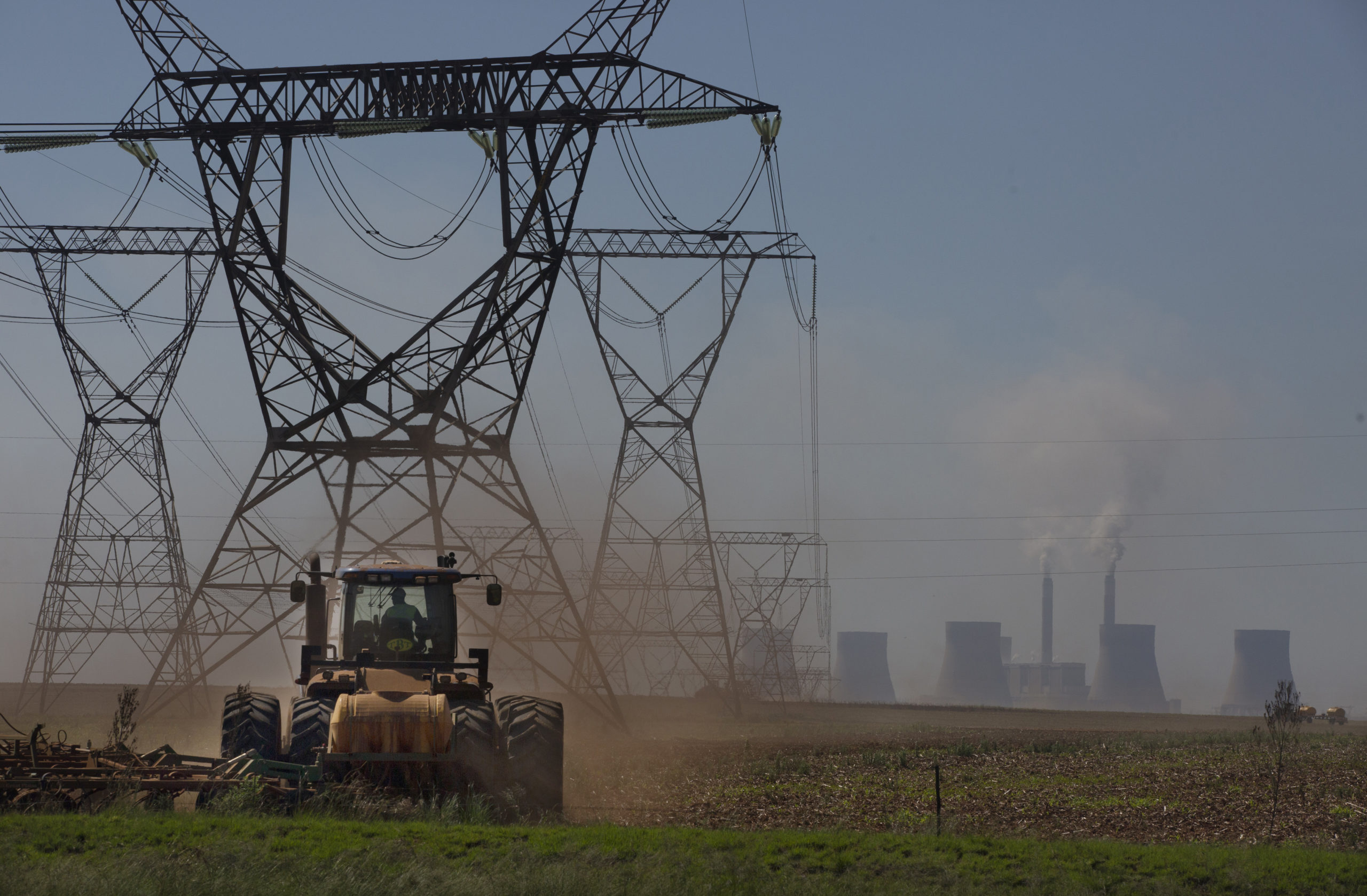 A farmer plows land underneath electrical pylons connected to the coal-powered electricity generating plant near Johannesburg, South Africa, on Thursday.