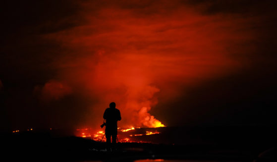 A photographer takes pictures of the erupting Mauna Loa volcano on Wednesday near Hilo, Hawaii.