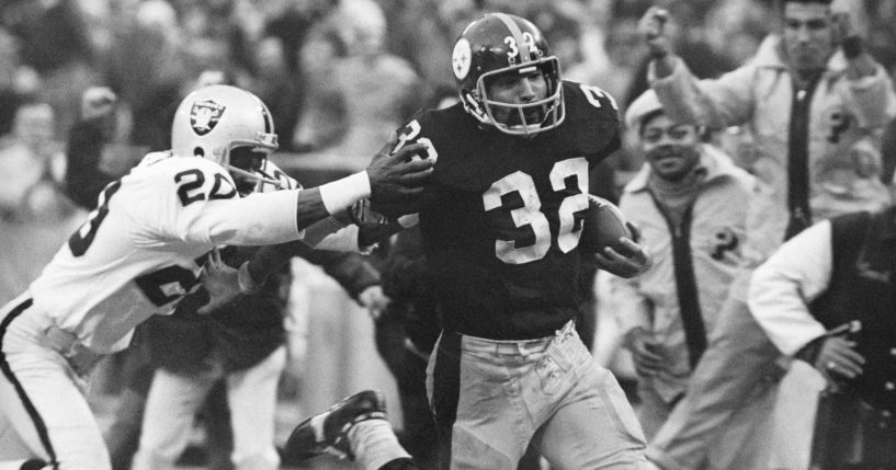 Pittsburgh Steelers’ Franco Harris eludes a tackle by Oakland Raiders’ Jimmy Warren as he runs 42-yards for a touchdown after catching a deflected pass during an AFC Divisional NFL football playoff game in Pittsburgh on Dec. 23, 1972.