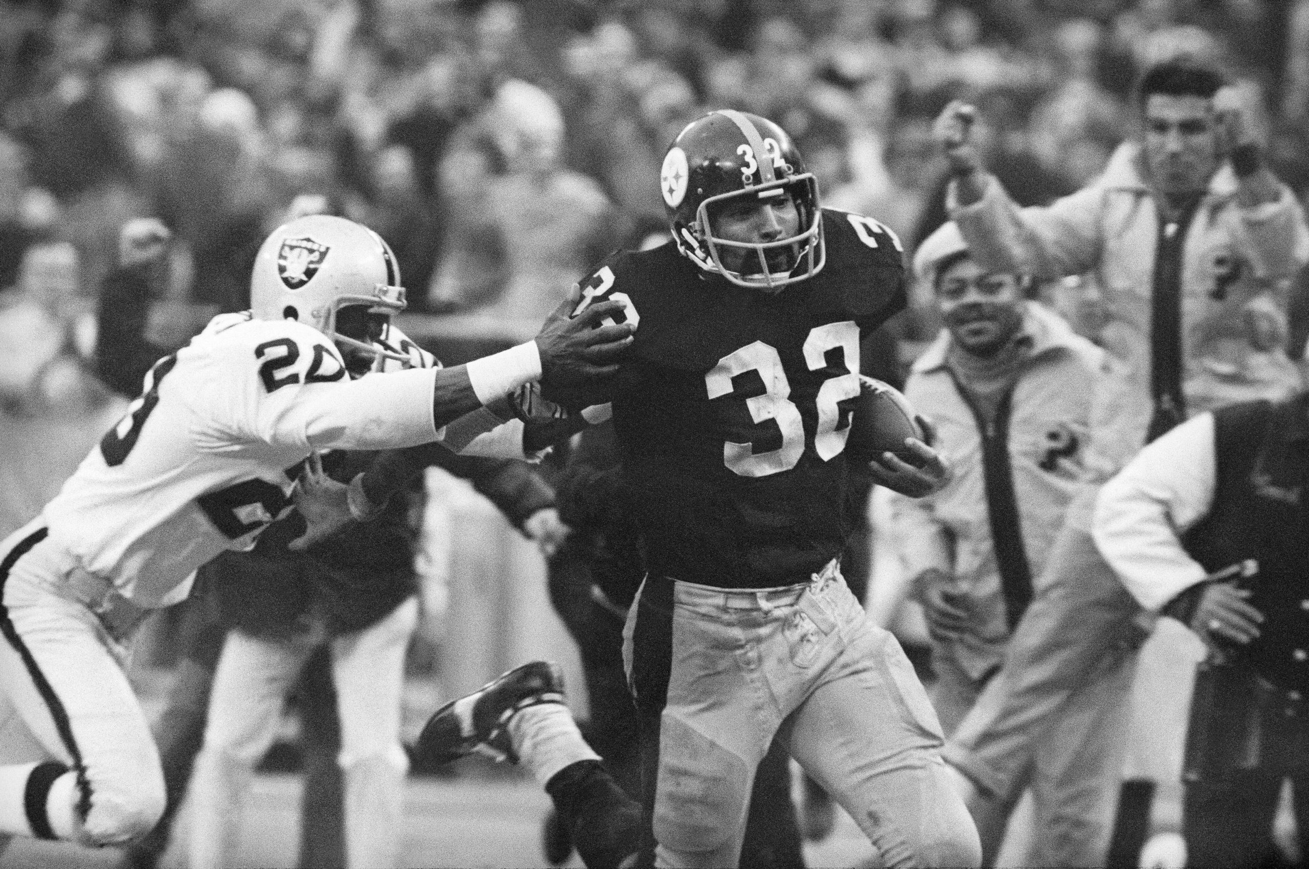 Pittsburgh Steelers’ Franco Harris eludes a tackle by Oakland Raiders’ Jimmy Warren as he runs 42-yards for a touchdown after catching a deflected pass during an AFC Divisional NFL football playoff game in Pittsburgh on Dec. 23, 1972.