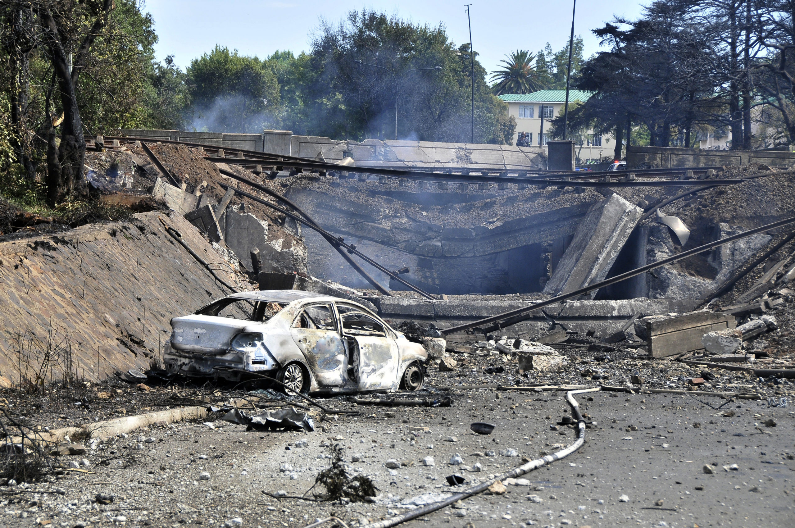 A burned-out vehicle marks the spot where a gas tanker exploded under a bridge in Boksburg, east of Johannesburg, South Africa, Saturday. A truck carrying liquified petroleum gas exploded, killing at least 8 people and injuring more than 50 others.