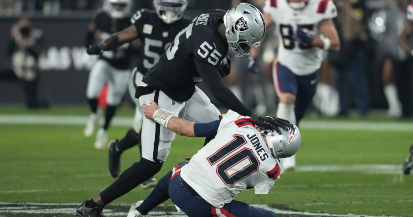 Las Vegas Raiders defensive end Chandler Jones breaks a tackle by New England Patriots quarterback Mac Jones to score a touchdown on an interception during the second half of an NFL football game between the New England Patriots and Las Vegas Raiders in Las Vegas on Sunday.