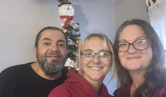 Pfc. Amiah Manlove, center, who is stationed with the U.S. Army in Oahu, Hawaii, poses with her mom Metika Beck Burke, right, and stepfather Stoney Burke, left, after she was finally able to make it home to Indianapolis on Sunday.