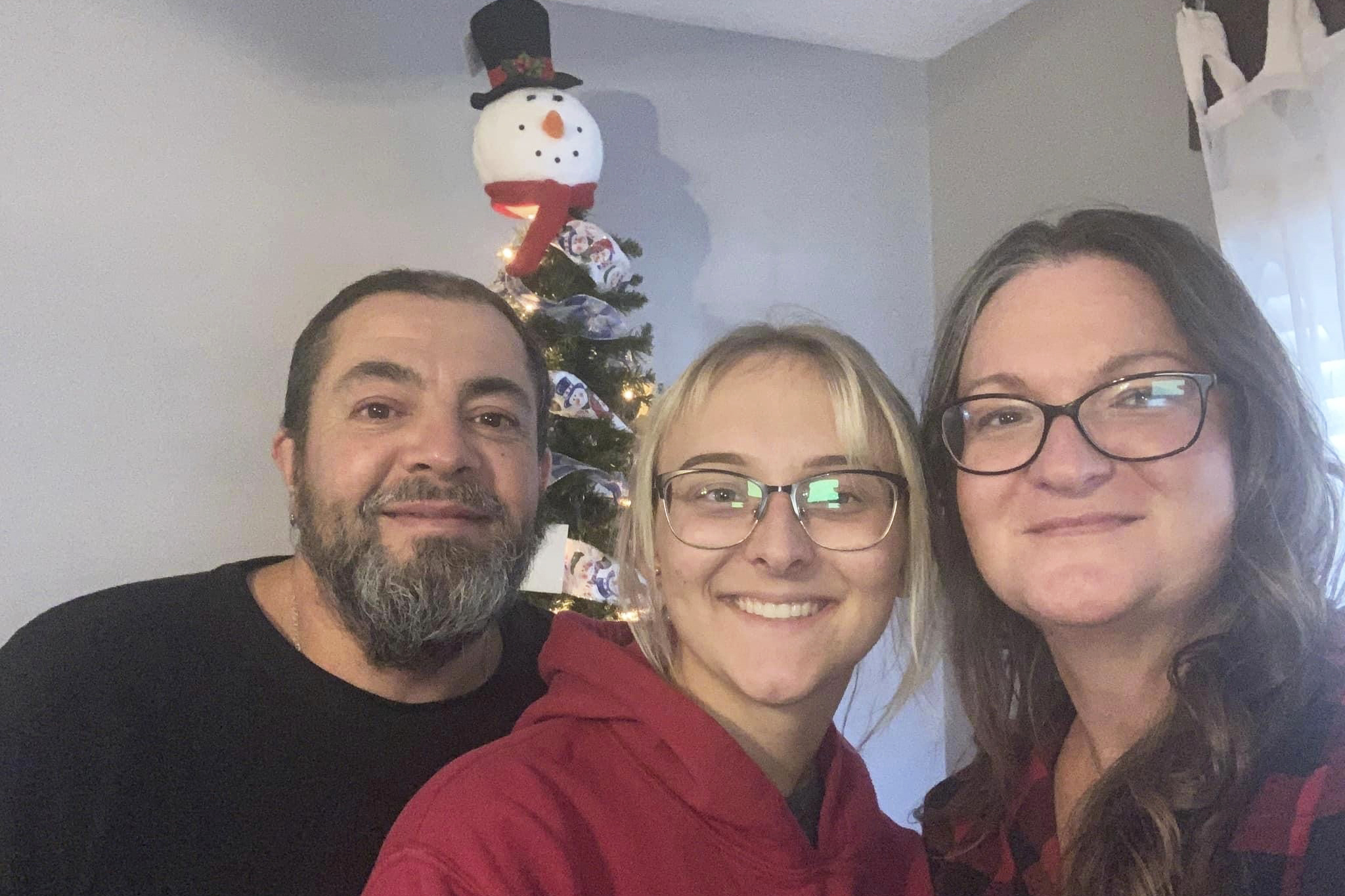 Pfc. Amiah Manlove, center, who is stationed with the U.S. Army in Oahu, Hawaii, poses with her mom Metika Beck Burke, right, and stepfather Stoney Burke, left, after she was finally able to make it home to Indianapolis on Sunday.