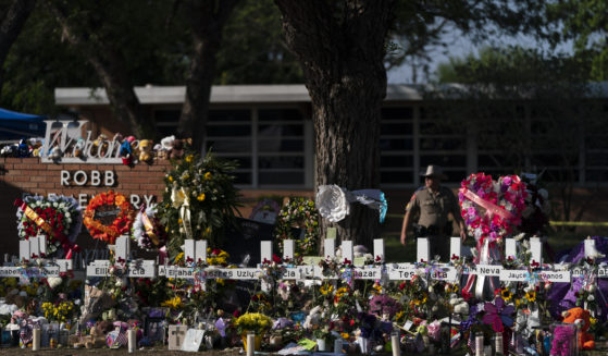 Flowers and candles are placed around crosses on May 28 at a memorial outside of Robb Elementary School in Uvalde, Texas.