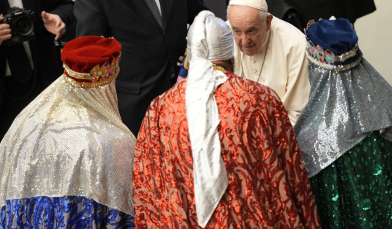 Pope Francis talks to men dressed as the three wise men at the end of his weekly general audience in the Paul VI Hall at the Vatican on Wednesday.