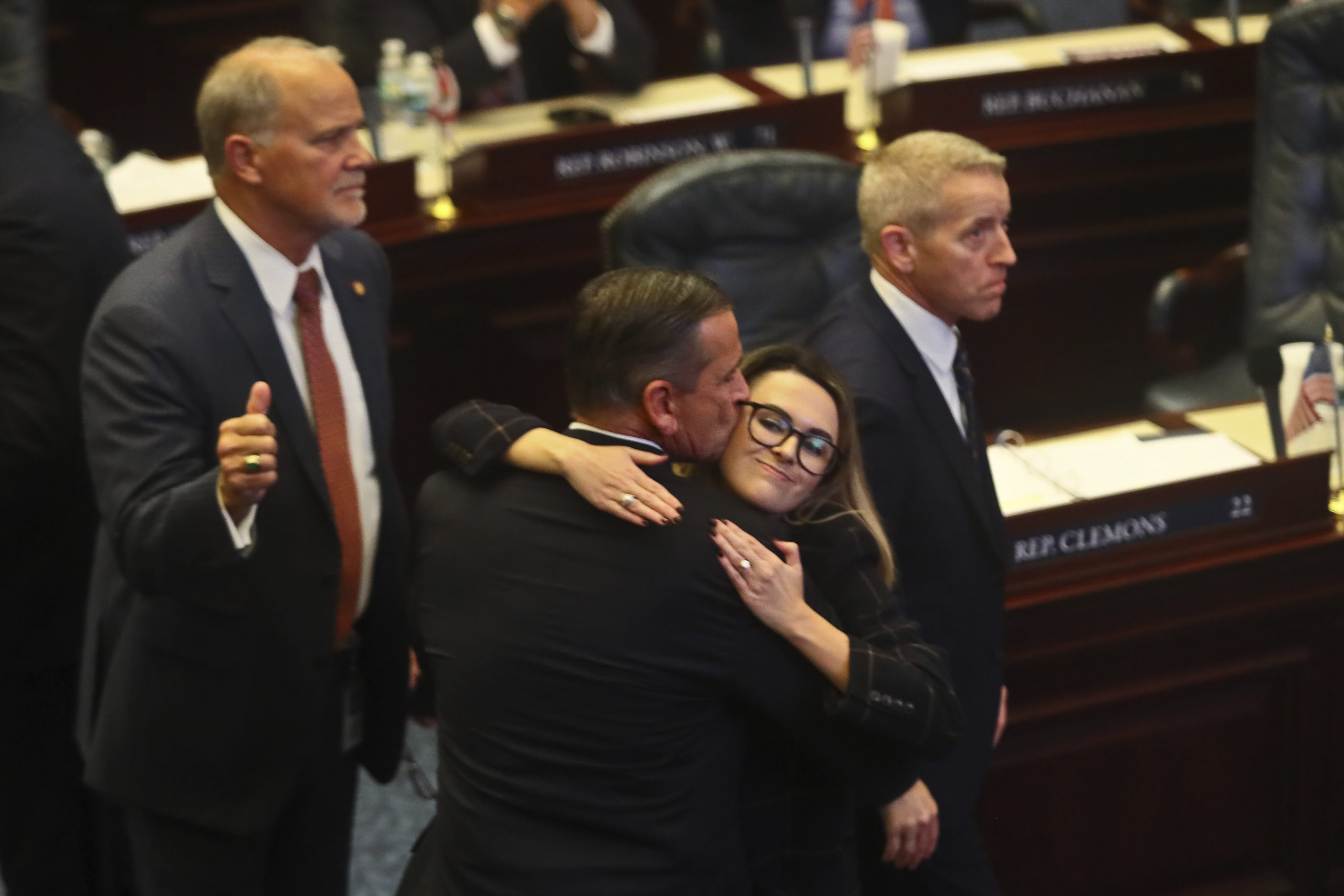 Florida Republican Rep. Bob Rommel of Naples, center, is hugged by Rep. Josie Tomkow of Polk City after his SB 2-A property insurance bill he co-sponsored passed Wednesday in the Florida House of Representatives. At left is Rep. Bobby Payne, R-Palatka; at right is House Speaker Paul Renner, R-Palm Coast. Florida lawmakers are meeting to consider ways to shore up the state's struggling home insurance market in the year's second special session devoted to the topic.