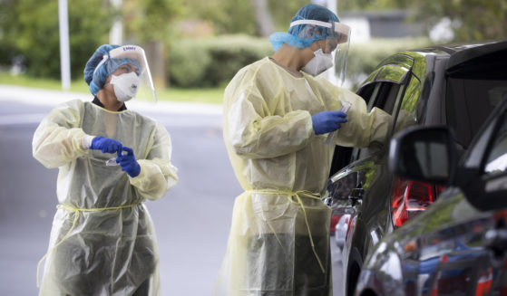 Technicians work to take samples as a community COVID testing center in Auckland, New Zealand on Dec. 28, 2021.