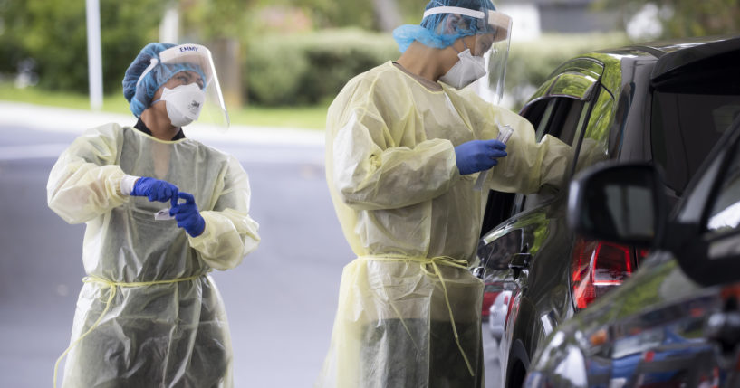 Technicians work to take samples as a community COVID testing center in Auckland, New Zealand on Dec. 28, 2021.