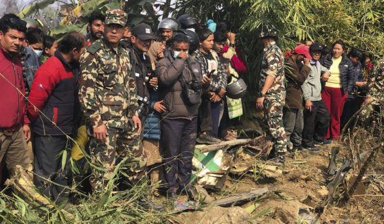 Locals of Pokhara, Nepal, gather to look at the wreckage of a regional plane that crashed on Sunday.