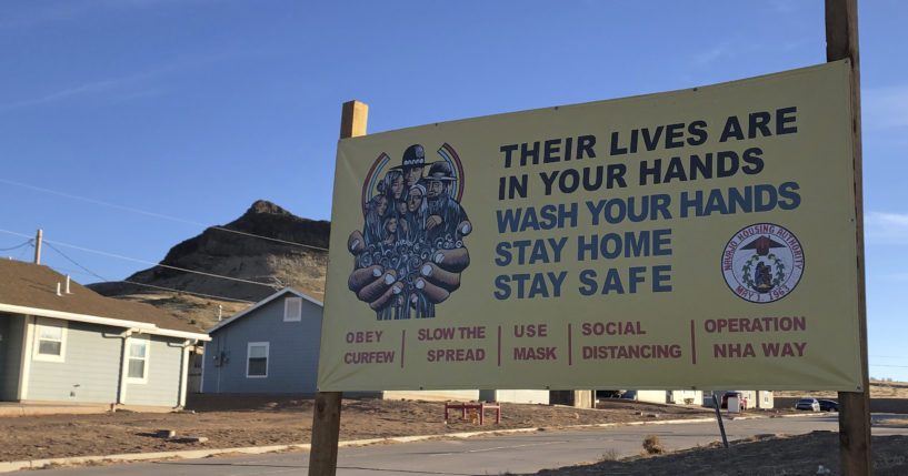 A sign urging safety measures during the coronavirus pandemic is displayed in Teesto, Arizona, on the Navajo Nation on Feb. 11, 2021.