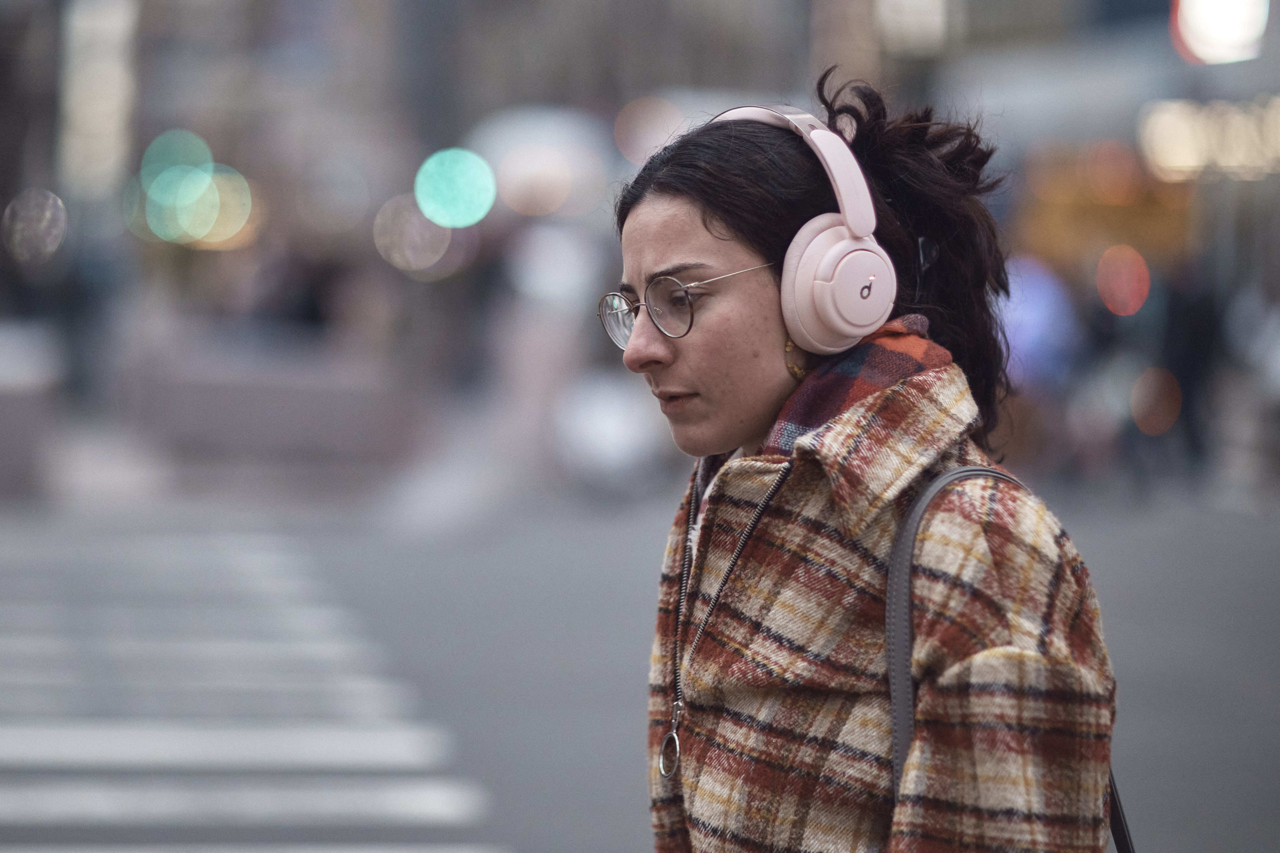 A woman using headphones walks in New York City on Tuesday.