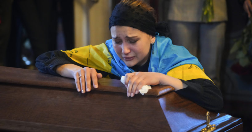 The widow of Ukrainian journalist and volunteer soldier Oleksandr Makhov cries over his coffin at St. Michael cathedral in Kyiv, Ukraine, on May 9.