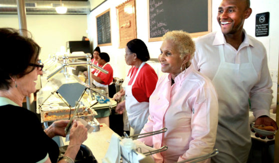 A customer picks up some food to-go from Sweetie Pie's owner Robbie Montgomery, center, and Montgomery's son, James "Tim" Norman, right, at Sweetie Pie's in St. Louis in 2011. Norman, the former star of a St. Louis-based TV reality show, was sentenced on Thursday to life in prison.