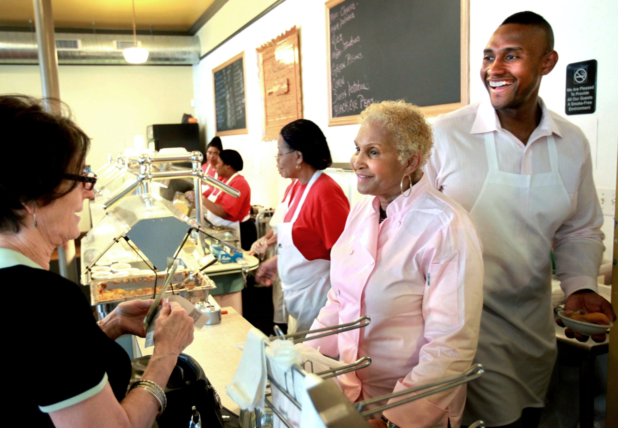 A customer picks up some food to-go from Sweetie Pie's owner Robbie Montgomery, center, and Montgomery's son, James "Tim" Norman, right, at Sweetie Pie's in St. Louis in 2011. Norman, the former star of a St. Louis-based TV reality show, was sentenced on Thursday to life in prison.