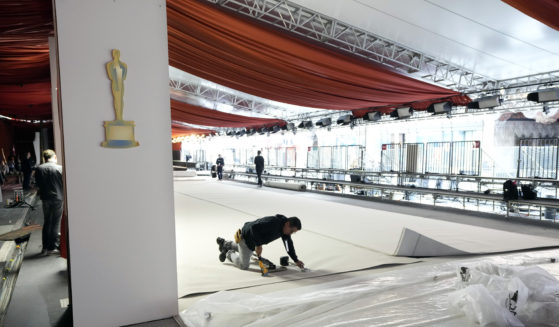 A crew member staples the carpet to the ground in preparation for Sunday's 95th Academy Awards in Los Angeles on Wednesday.