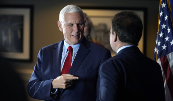 Former Vice President Mike Pence greets people while signing copies of his book "So Help Me God" before the start of a GOP fundraising dinner on Thursday in Keene, New Hampshire.