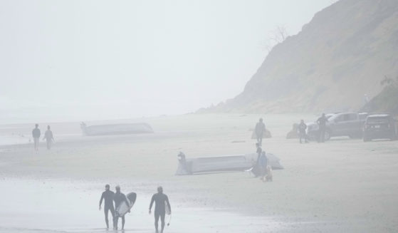 Two boats, one which had overturned in the water, sit on Blacks Beach in San Diego, California, on Sunday.