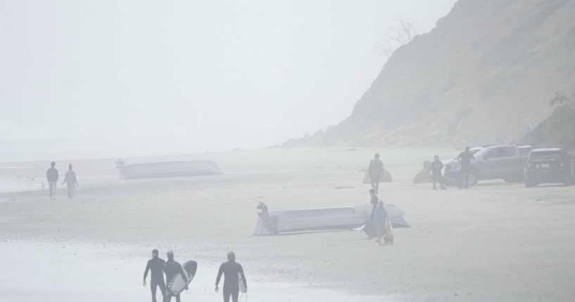 Two boats, one which had overturned in the water, sit on Blacks Beach in San Diego, California, on Sunday.