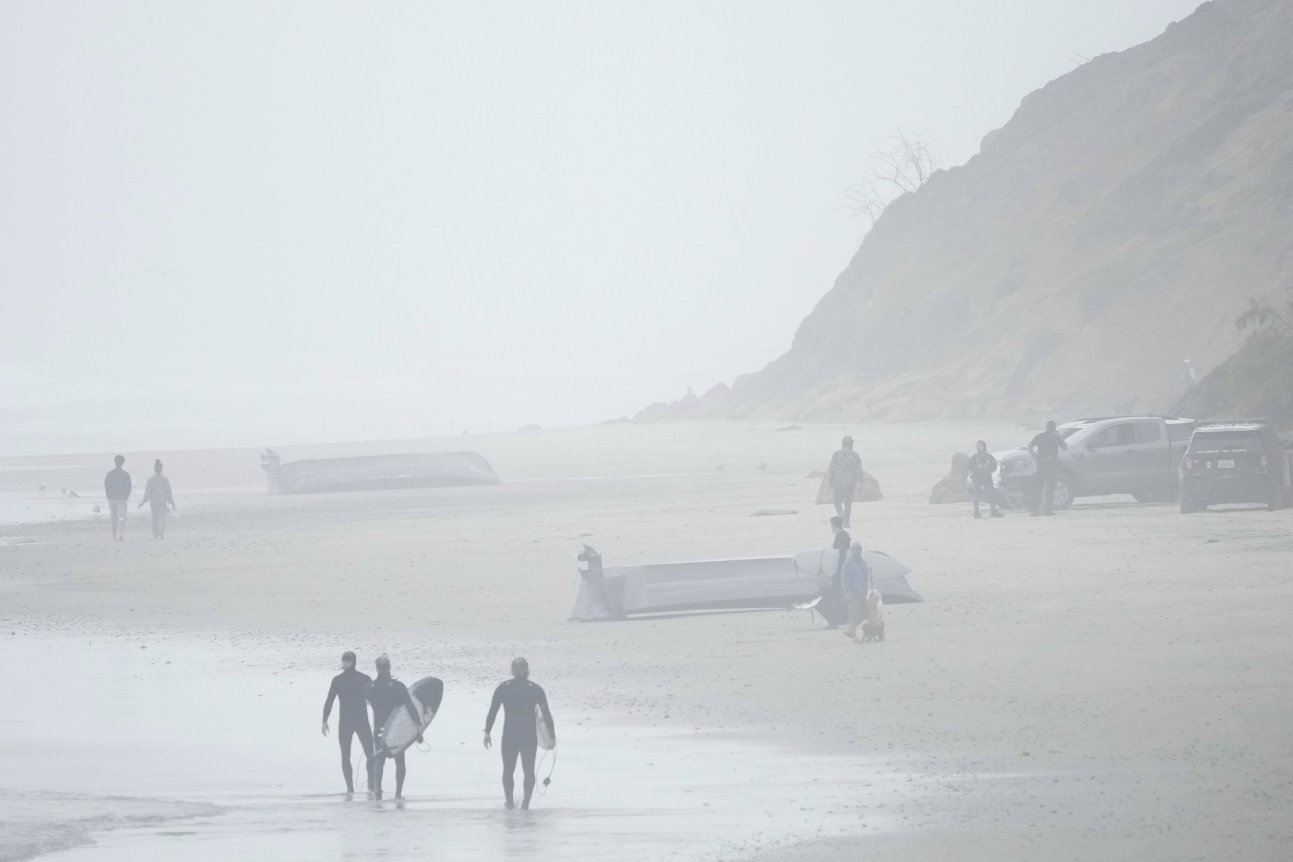 Two boats, one which had overturned in the water, sit on Blacks Beach in San Diego, California, on Sunday.