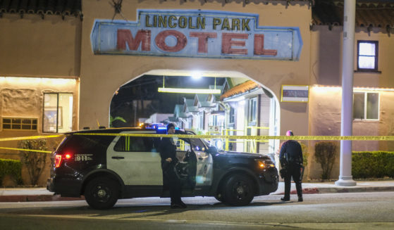 Police officers stand guard near a crime scene where three Los Angeles officers were shot Wednesday in the city's Lincoln Heights neighborhood. Police said the officers were hospitalized in stable condition.