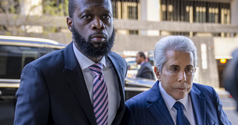 Rapper Prakazrel "Pras" Michael, left, walks into a federal court with his attorney, David Kenner, on March 30, in Washington, D.C.