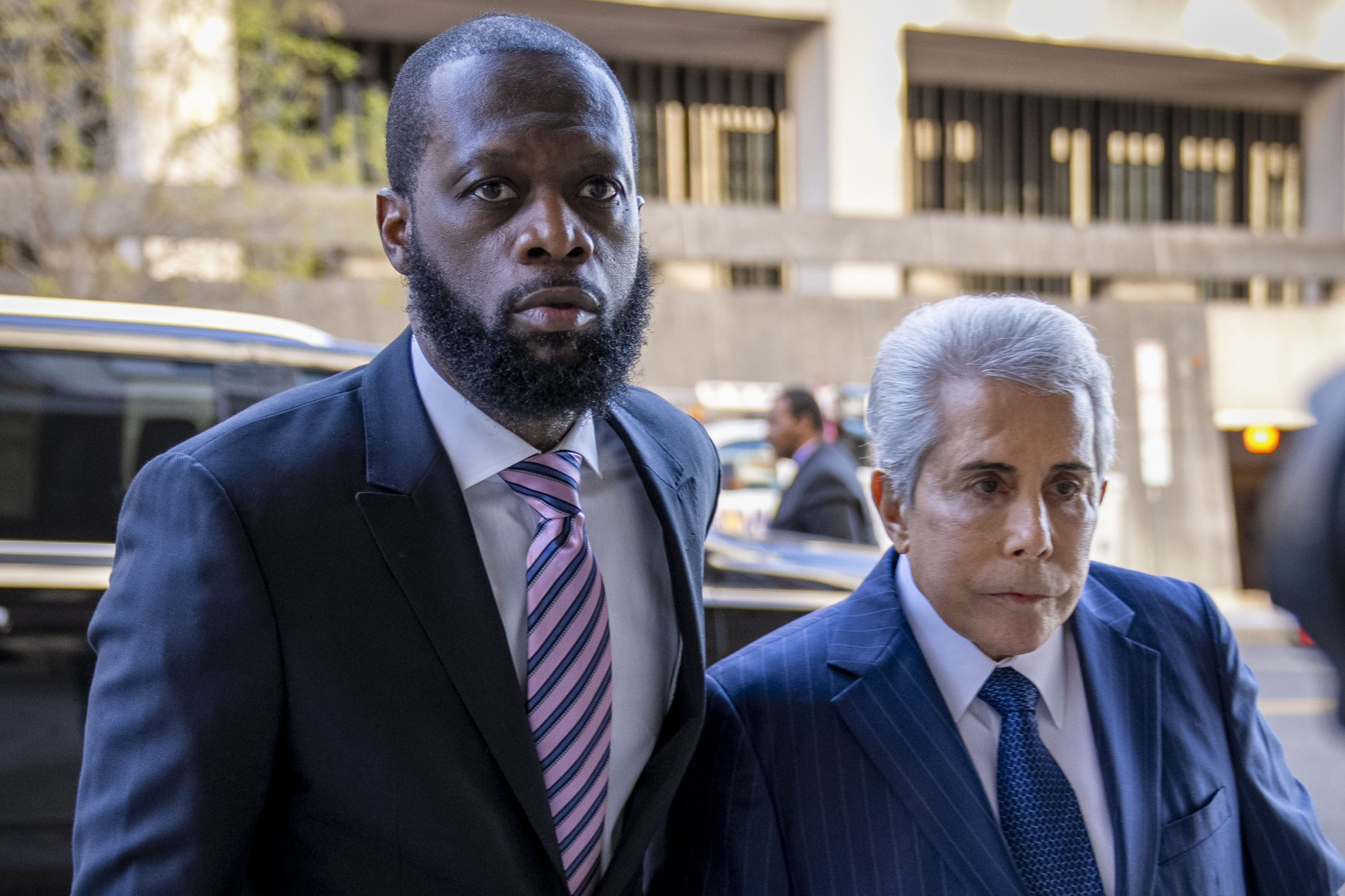 Rapper Prakazrel "Pras" Michael, left, walks into a federal court with his attorney, David Kenner, on March 30, in Washington, D.C.