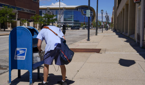 A postal worker emptying a mailbox