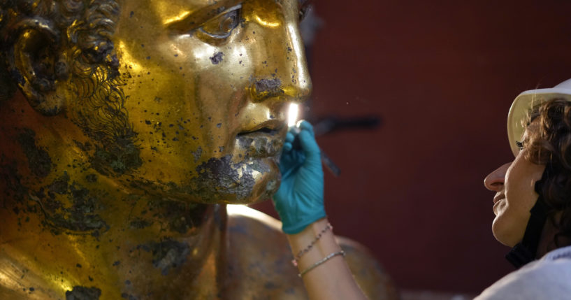 Vatican Museum restorer Alice Baltera works on the bronze Hercules statue in the Round Hall of the Vatican Museums on Thursday.