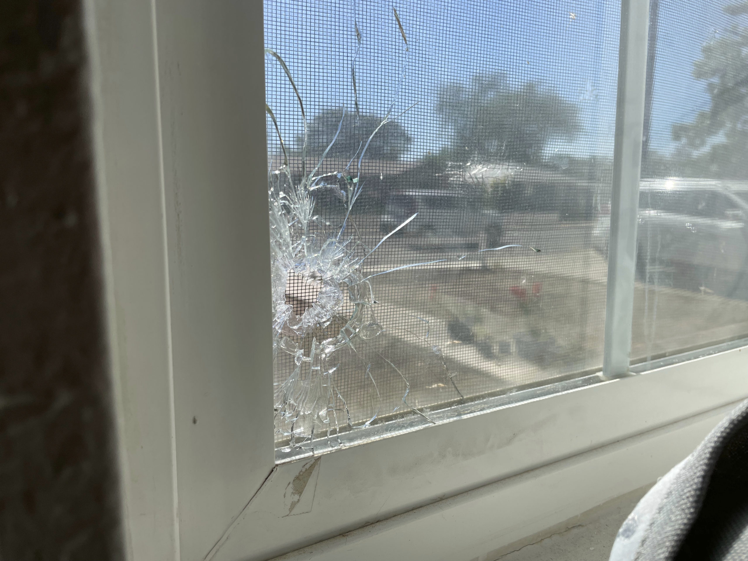 A bullet hole is seen through the bedroom window of Jolene Robledo's home Tuesday in Farmington, N.M. It was among the damage resulting from a deadly shooting along a residential street in the northwestern New Mexico community.