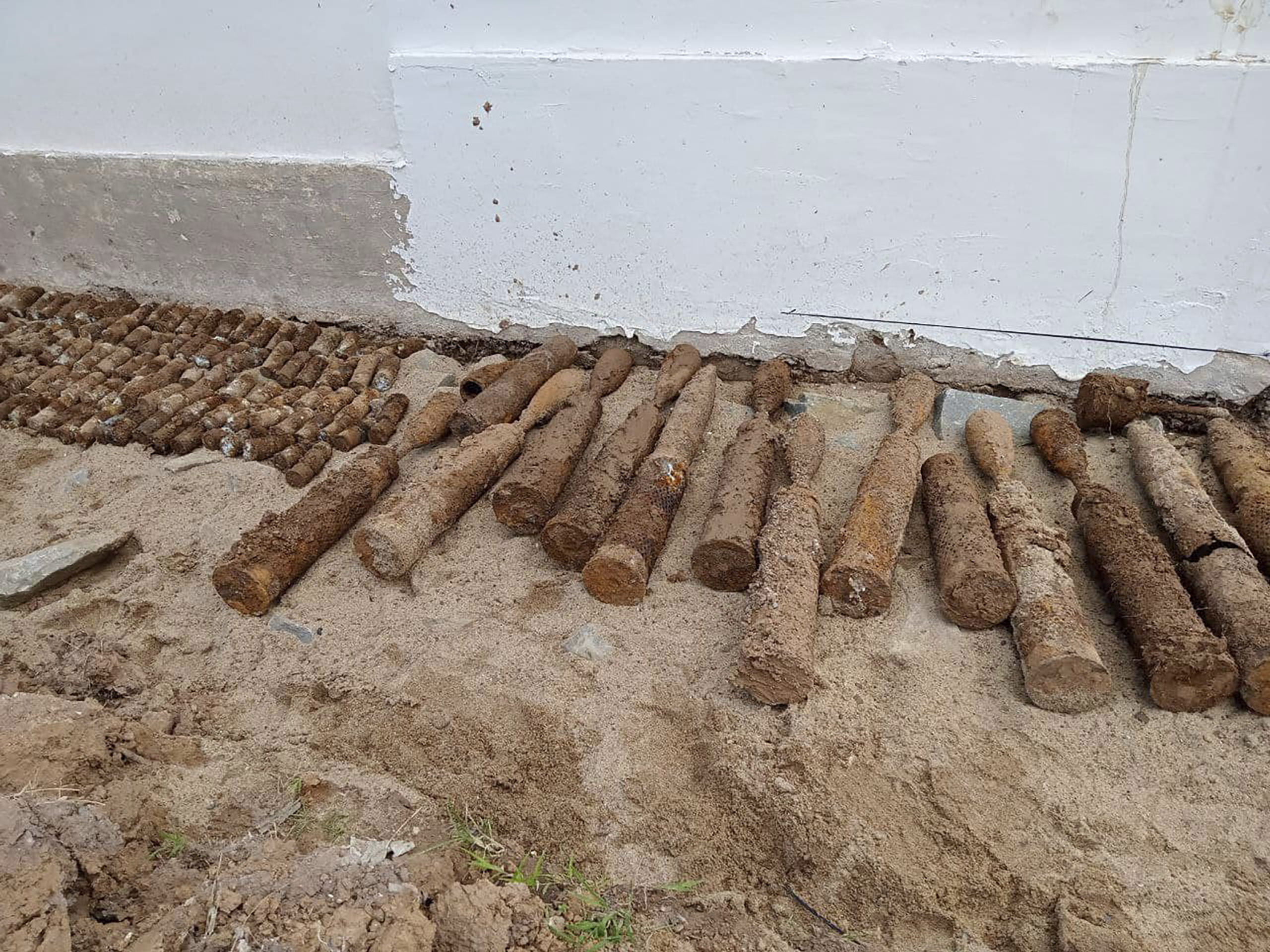 A photo released by the Cambodia Mine Action Center shows dirt-caked, unexploded ordnance at Queen Kosamak High School in Kratie Province, northeast of Phnom Penh, Cambodia, on Sunday.