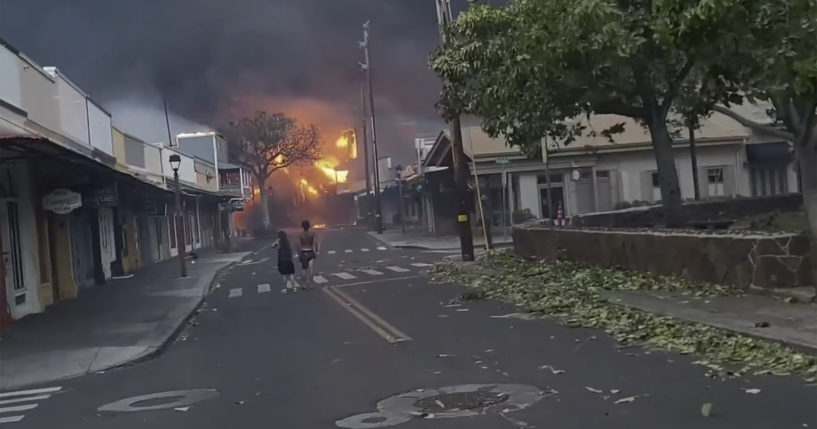 People walk the streets of Lahaina town, Hawaii, on Wednesday as wildfires engulf multiple structures, forcing residents to evacuate.