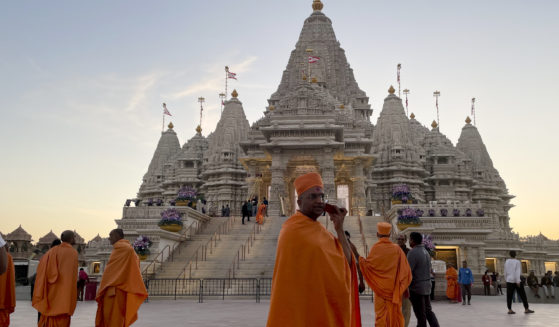 Monks in saffron robes walk in front of the BAPS Swaminarayan Akshardham temple on Wednesday in Robbinsville, New Jersey.