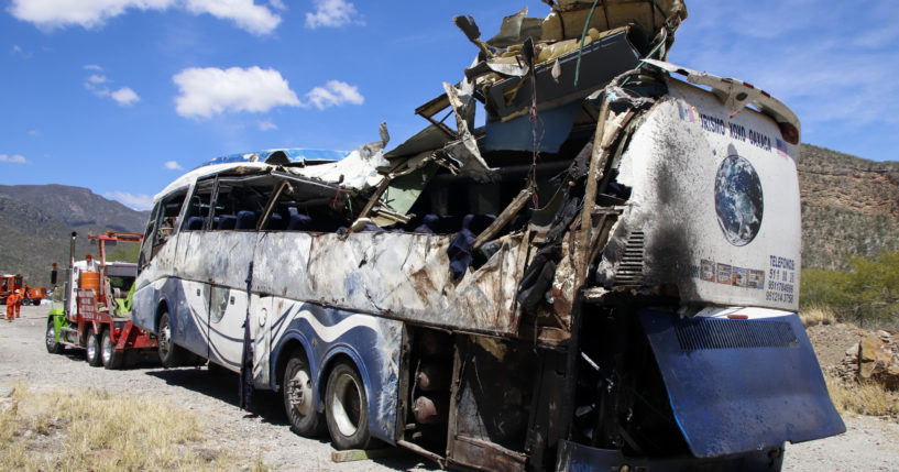 A bus involved in a deadly crash sits attached to a tow truck on the side of the road Friday near Tepelmeme, Oaxaca state, in Mexico.