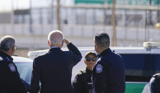 President Joe Biden, second from left, looks towards a large “Welcome to Mexico” sign that is hung over the Bridge of the Americas as he tours the El Paso, Texas, port of entry on Jan. 8.