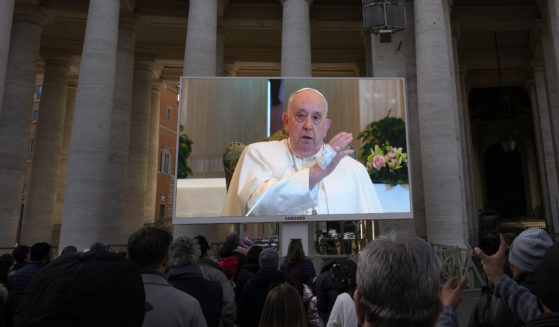 A giant screen broadcasts Pope Francis delivering his blessing during the Angelus noon prayer from the chapel of the hotel at the Vatican grounds in the Vatican City on Sunday.