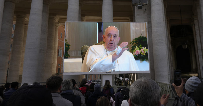 A giant screen broadcasts Pope Francis delivering his blessing during the Angelus noon prayer from the chapel of the hotel at the Vatican grounds in the Vatican City on Sunday.