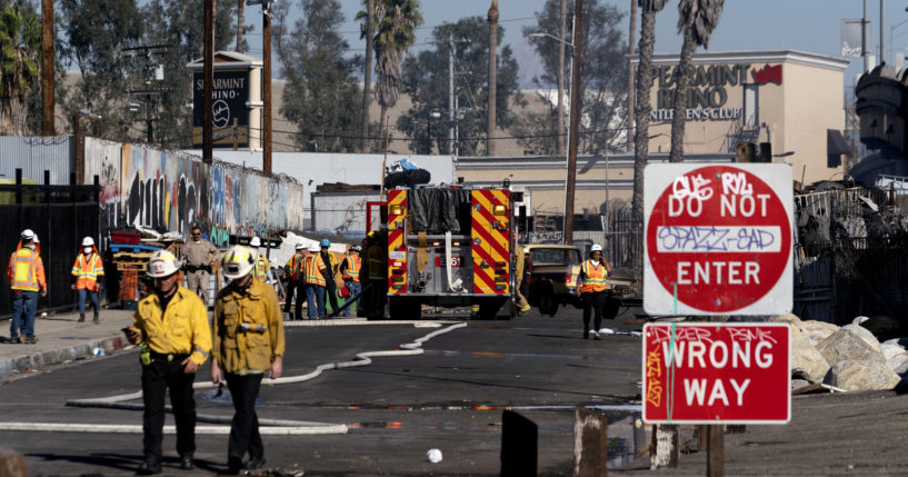 Los Angeles firefighters work to clean up the damage from a fire that severely damaged part of Interstate 10 in Los Angeles on Saturday. There has been no date given for when the section of road will reopen.