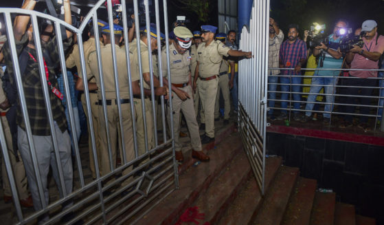 A police officer inspects a spot after a stampede Saturday at the Cochin University of Science and Technology in Kerala state, India. Four people died in the incident.