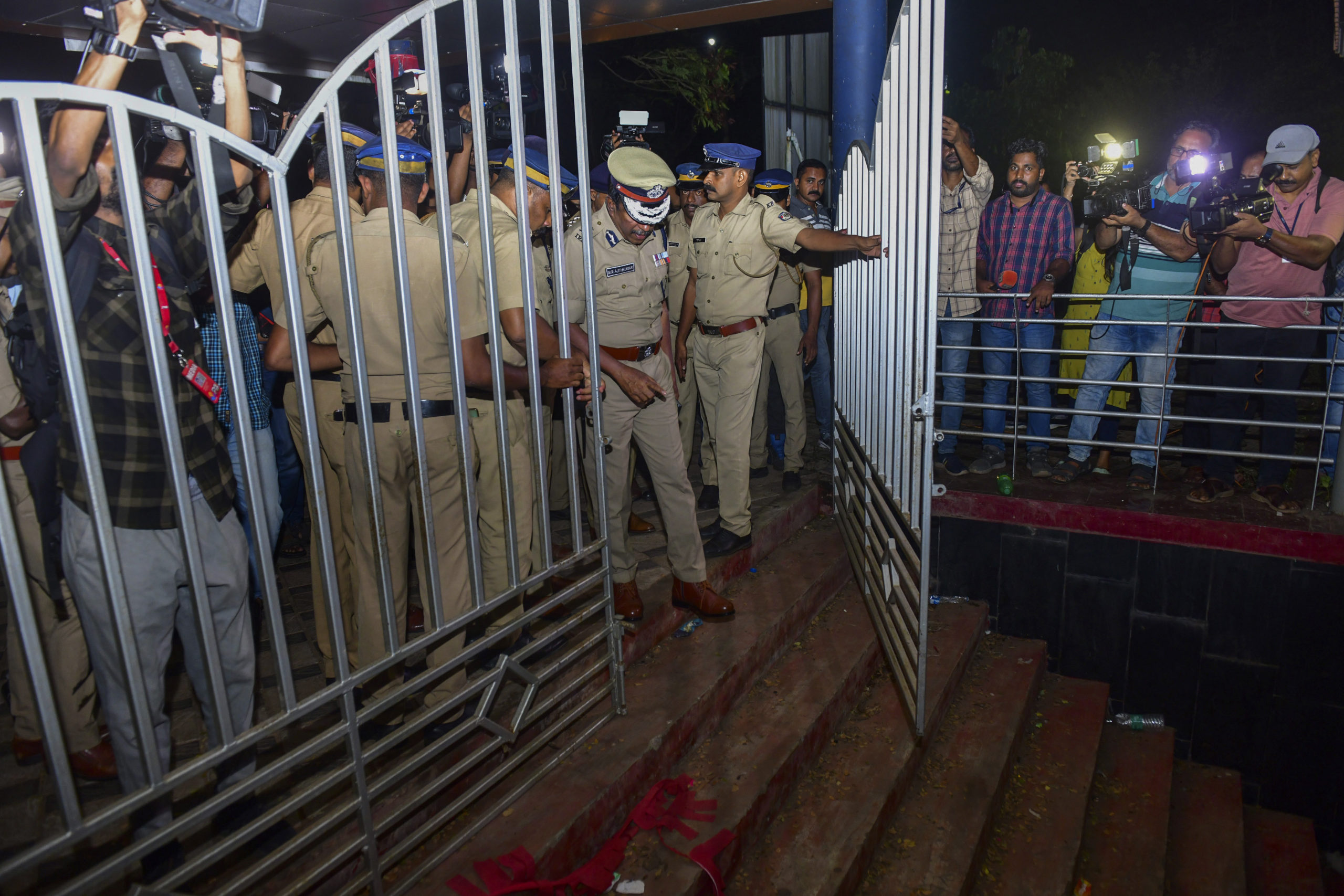 A police officer inspects a spot after a stampede Saturday at the Cochin University of Science and Technology in Kerala state, India. Four people died in the incident.