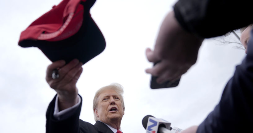 Republican presidential candidate former President Donald Trump hands off a signed hat during a campaign stop in Londonderry, New Hampshire, on Tuesday.