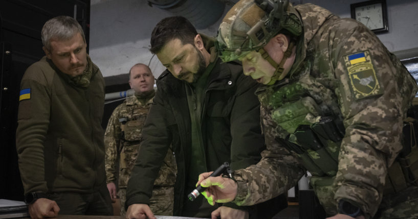 Ukrainian President Volodymyr Zelenskyy (center) and Col.-Gen. Oleksandr Syrskyi (far right) look at a map during a meeting in the front-line city of Kupiansk, Ukraine, on Nov. 30, 2023.