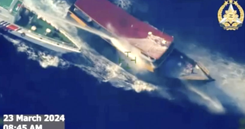 In this screen grab from video, a Chinese coast guard ship uses water cannons and closely maneuvers beside a Philippine resupply vessel as it approaches Second Thomas Shoal, at the disputed South China Sea on Saturday.