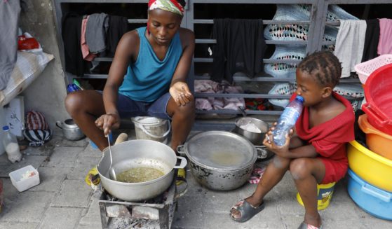 A woman cooks at a shelter for families displaced by gang violence in Port-au-Prince, Haiti, Friday.