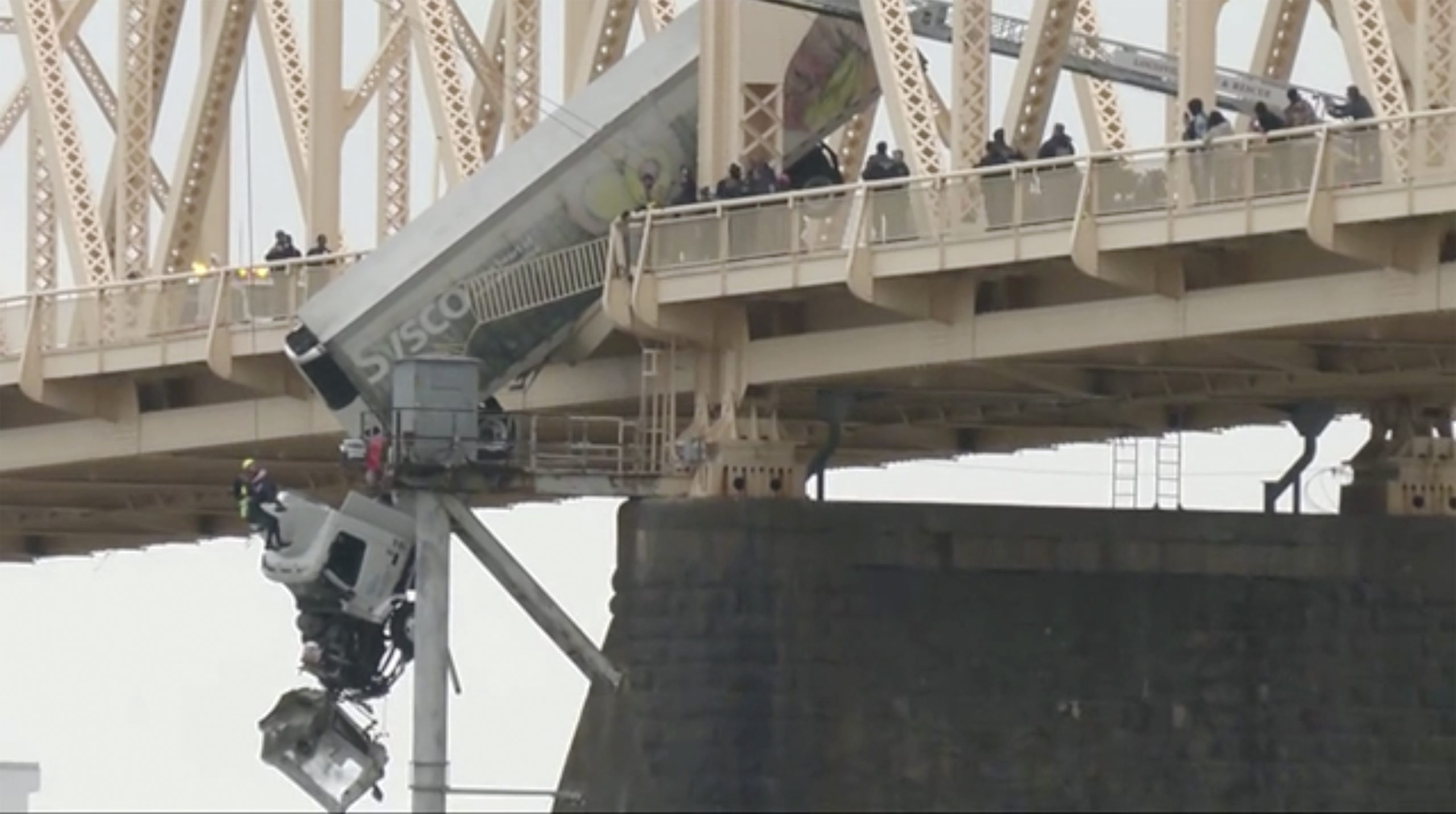 The driver of a semi-truck was pulled to safety Friday by firefighters in Louisville, Kentucky, following a crash that left the vehicle dangling over a bridge across the Ohio River.