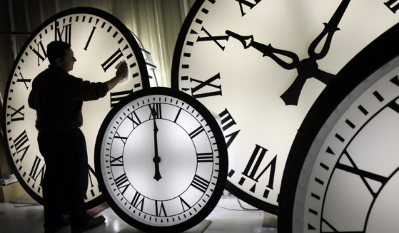 An Electric Time Co. employee cleans the face of an 84-inch Wegman clock at the plant in Medfield, Massachusetts, in 2008. Most Americans will set their clocks forward by one hour this weekend, to daylight saving time.