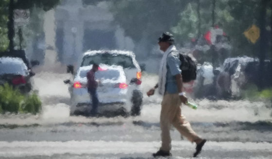 A person crosses Caroline Street in the afternoon heat Saturday, May 25, 2024, near Discovery Green in Downtown Houston.