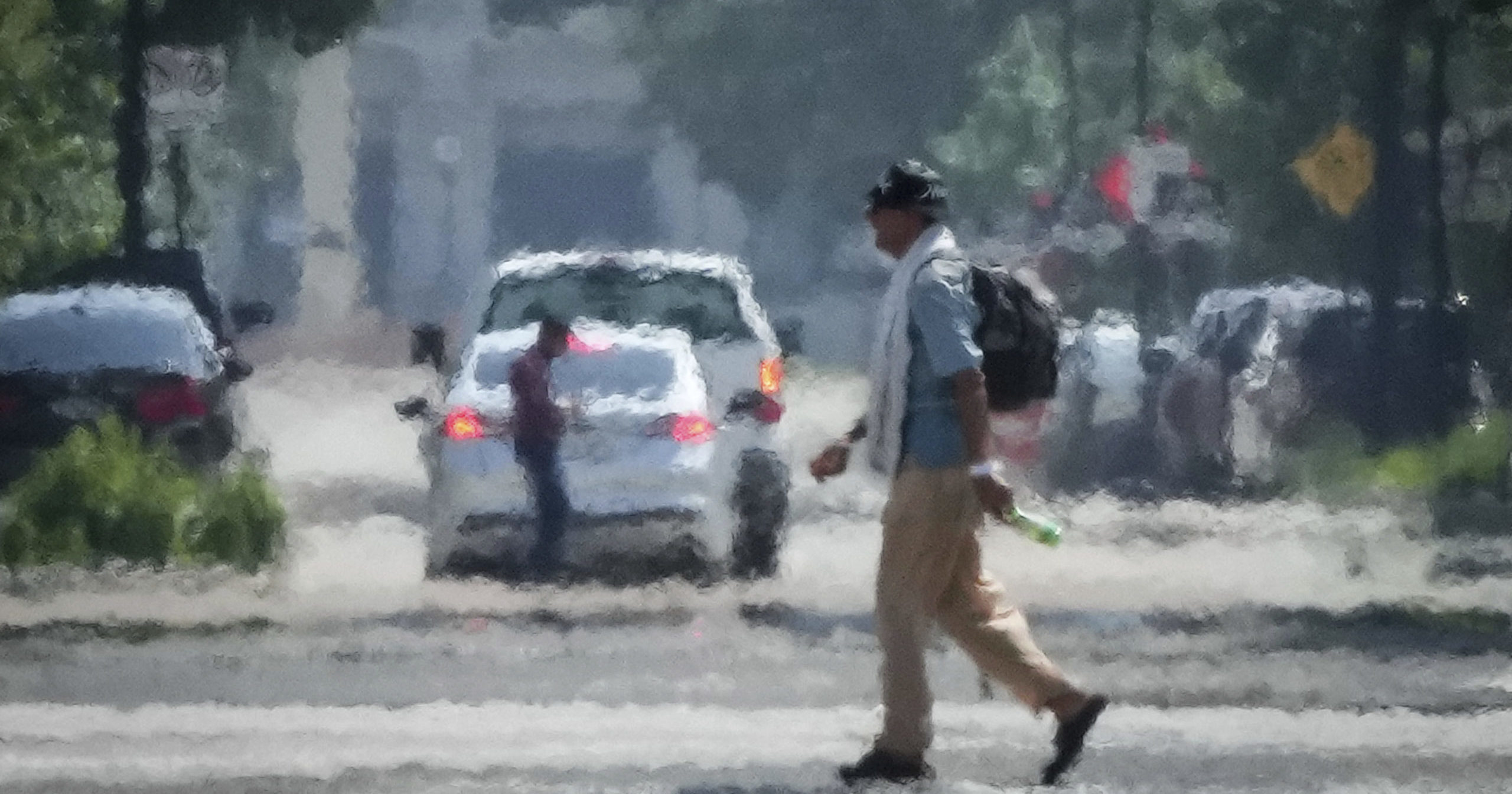 A person crosses Caroline Street in the afternoon heat Saturday, May 25, 2024, near Discovery Green in Downtown Houston.