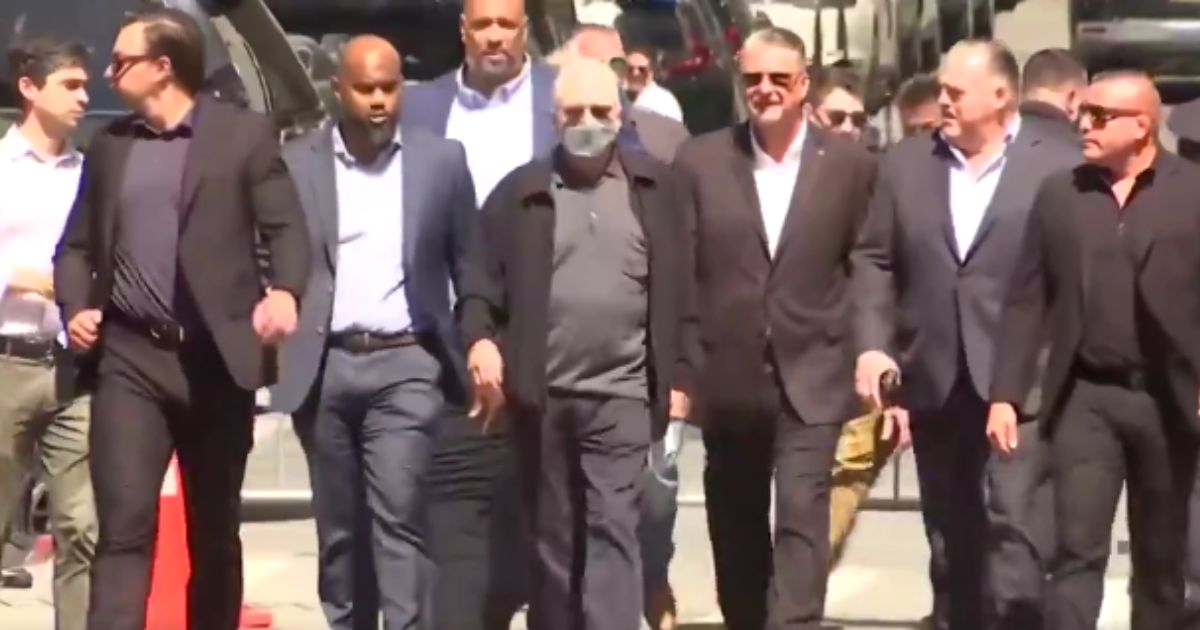 A Biden campaign representative, second from left; Robert De Niro, center; and others, including two officers present at the Capitol incursion, make their way to the media for a Biden campaign news conference outside the Manhattan courthouse on Tuesday where Trump's trial is taking place.